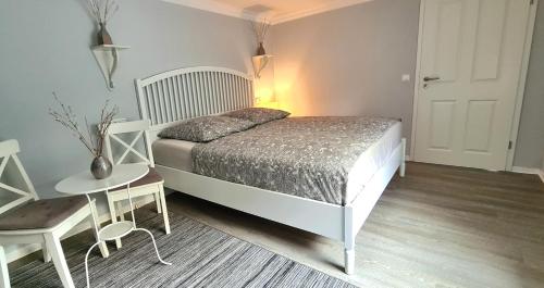 a bedroom with a bed and a table and a door at Apartment Mai in Elmenhorst