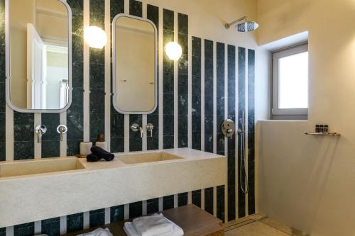 a bathroom with a sink and a mirror at Camarades Mykonos in Ano Mera