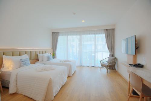 a hotel room with two beds and a desk at Infinity Aonang Krabi in Ao Nang Beach