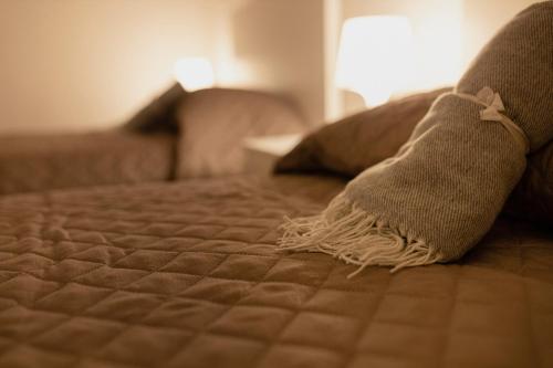a bed with two pillows on top of it at Dimora 1919 Luxury Loft in Matera