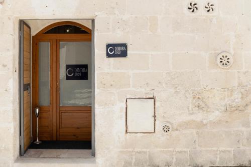 a door to a building with two signs on it at Dimora 1919 Luxury Loft in Matera
