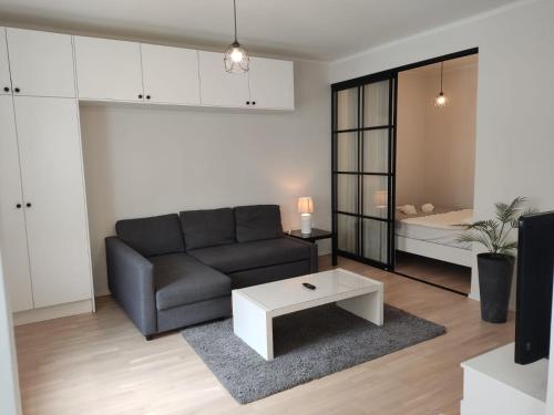 uma sala de estar com um sofá e uma mesa em Adorable Central Apartment Helsinki em Helsinque