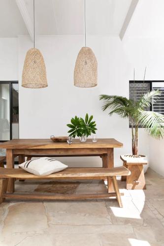 a dining room with a wooden table and potted plants at Coral villa in Byron Bay