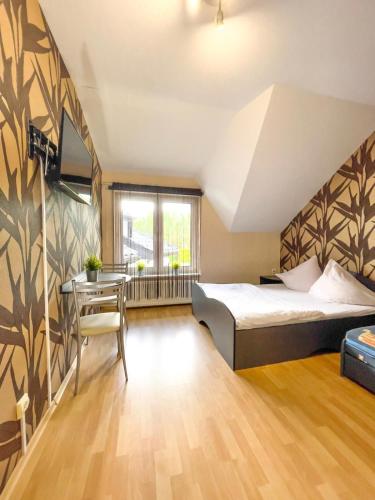 a bedroom with a bed and a desk and a table at Brydar with Sauna, Swimming Pool and Jacuzzi in Mielno