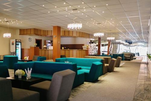 a waiting room with blue couches and tables in a building at Hotel Slovakia in Žilina