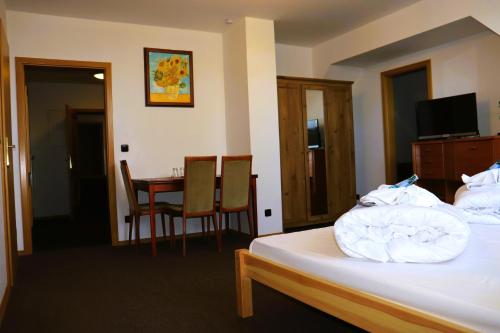 a hotel room with a bed and a table and chairs at Schwarzes Ross Hotel & Restaurant Oberwiesenthal in Kurort Oberwiesenthal