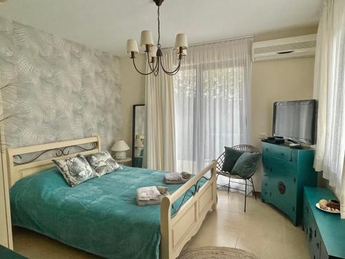 a bedroom with a bed and a tv and a chandelier at Private seaview villa in BlackSeaRama - 1st line in Balchik