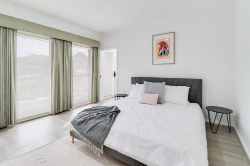 a white bedroom with a large bed and windows at Highton Accommodation (Geelong) in Geelong
