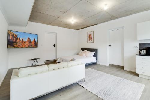 a white living room with a white couch and a bed at Highton Accommodation (Geelong) in Geelong