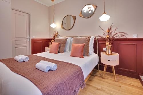 een slaapkamer met een groot bed en handdoeken bij Miss Marguerite Suite in Parijs