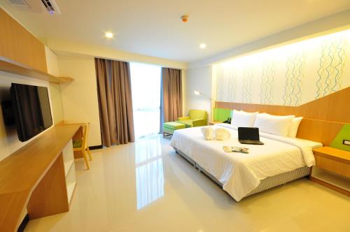 a hotel room with a bed with a laptop on it at 42C The Chic Hotel in Nakhon Sawan