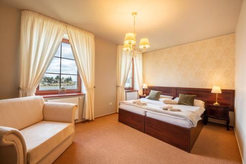 1 dormitorio con cama, sofá y ventana en Hotel Plumlov, en Mostkovice