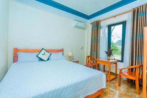 a bedroom with a white bed and a window at Phong Nha Green Homestay in Phong Nha