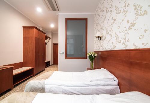 a hotel room with two beds and a mirror at Hotel Park Kajetany in Nadarzyn