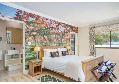 a bedroom with a bed and a tree mural at Florin’s Crest 3 Bedroom Villa, Franschhoek in Franschhoek
