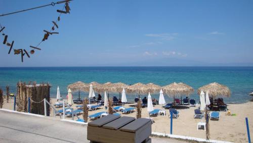 una playa con sombrillas y sillas y el océano en Villa Giotis Suite, en Skala Sotiros
