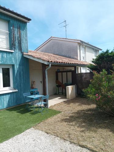 una casa azul con una mesa de picnic en el patio en Maison de vacance mi ville, mi campagne, en Boé