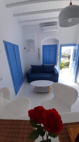 a living room with a couch and a vase with a red rose at BAROS VIEW in Apérathos