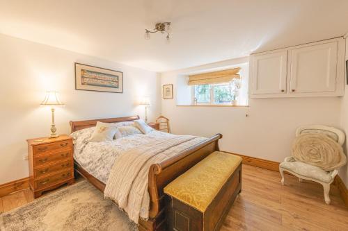 a bedroom with a bed and a chair and a window at The Flat at number 11 in Newton Abbot