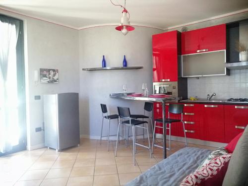 uma cozinha com armários vermelhos e um balcão com bancos em Casa VistaLago Vertine em Sulzano