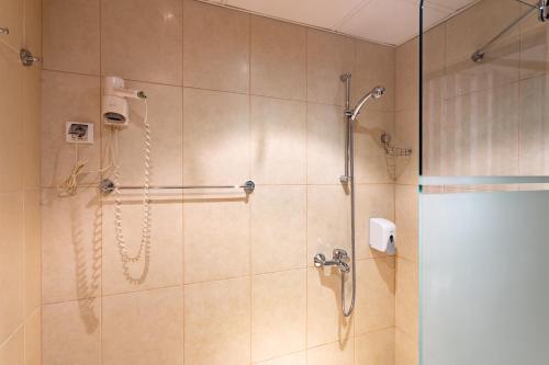 a bathroom with a shower with a glass door at Real Hotel in Veliko Tŭrnovo