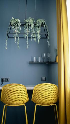 two chairs in front of a table with flowers at RUMI Hotel with Self Check-In in Jēkabpils