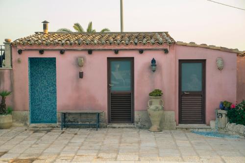 a pink house with two doors and a vase at Villa Virginia in Ragusa