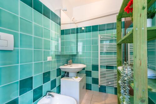 uma casa de banho com paredes em azulejos azuis e um lavatório. em Morena - YourPlace Abruzzo em Fossacesia