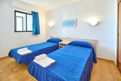 two beds in a room with blue sheets at Don Gregorio-Fincas Benidorm in Benidorm