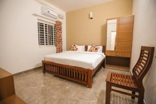 a bedroom with a bed and a chair at VIPRA HOTEL in Coimbatore