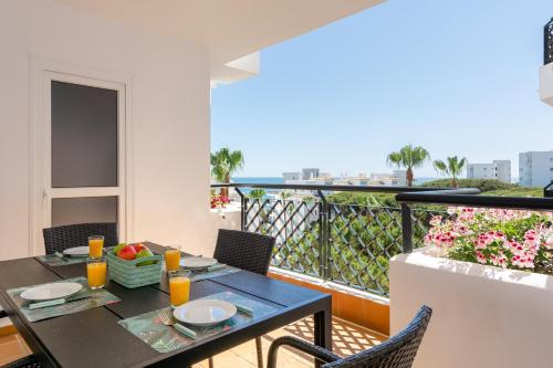 einen Esstisch auf einem Balkon mit Meerblick in der Unterkunft Mi Capricho Playa Marbella in Sitio de Calahonda
