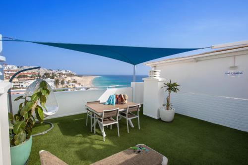 a balcony with a table and a view of the ocean at ALTAVISTA APARTAHOTEL-Adults Only over 14 in Morro del Jable
