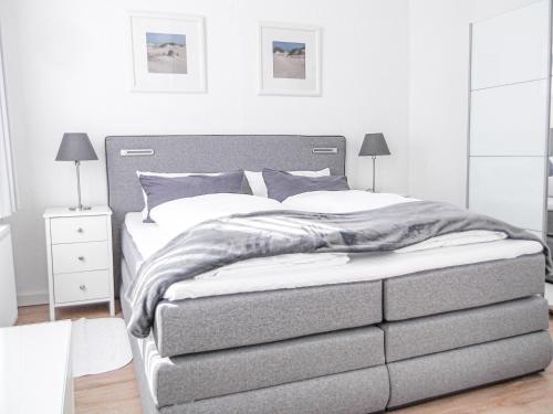 ein Schlafzimmer mit einem großen Bett mit grauem Rahmen in der Unterkunft Haus Westwind Hallwegh 04 in Norderney