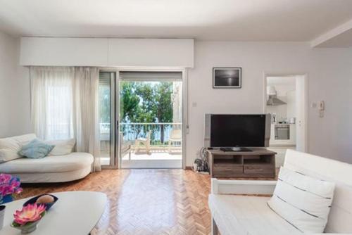 a living room with a white couch and a television at Myria Court in Limassol