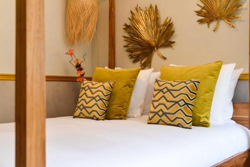 - un lit avec des oreillers verts et blancs dans l'établissement The Majestic Garden Suite, à Paris