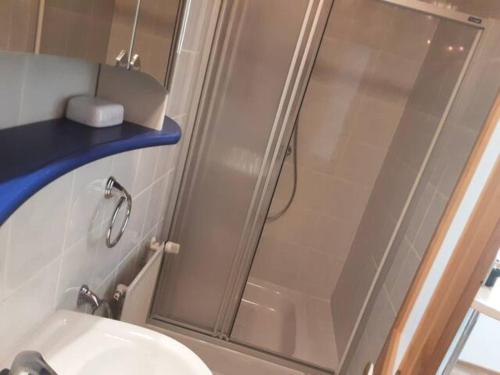 a shower with a glass door next to a sink at Apartment-Ferienwohnung 3 Treffen am Ossiachersee in Treffen