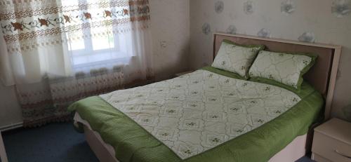 - une chambre avec un lit doté de draps verts et une fenêtre dans l'établissement Brick House, à Lahıc