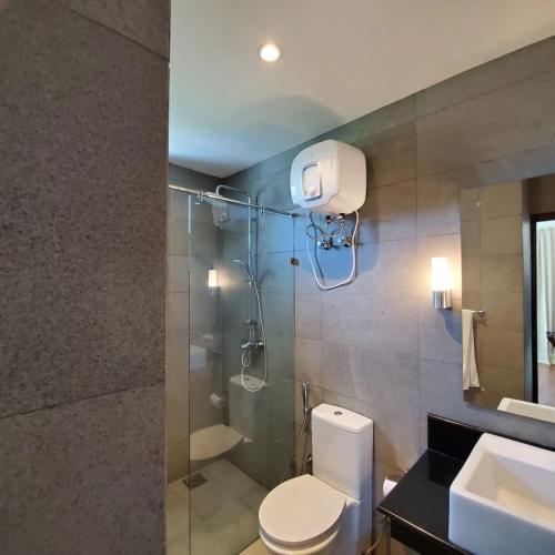 ein Badezimmer mit Dusche, Toilette und Waschbecken in der Unterkunft Trincomalee Ocean Front Condos in Trincomalee