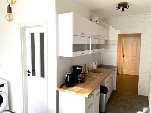 une cuisine avec des placards blancs et un comptoir en bois dans l'établissement Dream Apt Mikulov, à Mikulov