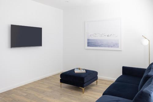 a living room with a blue couch and a ottoman at Kuzman Estates in Mudgee