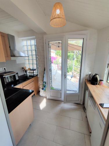 une cuisine avec une porte menant à une terrasse dans l'établissement La Vallicella, à Farinole