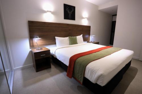 a bedroom with a large bed in a hotel room at Flinders Street Apartments in Melbourne