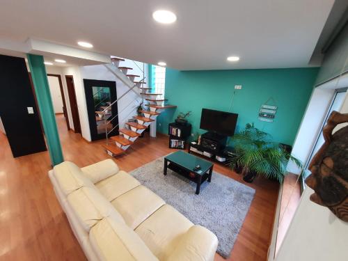a living room with a couch and a stair case at Cabedelo Beach House in Viana do Castelo