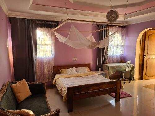 - une chambre avec un lit, une chaise et des rideaux dans l'établissement Villa Jane, à Arusha