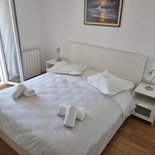 a white bed with two towels on top of it at Villa Mila in Bol