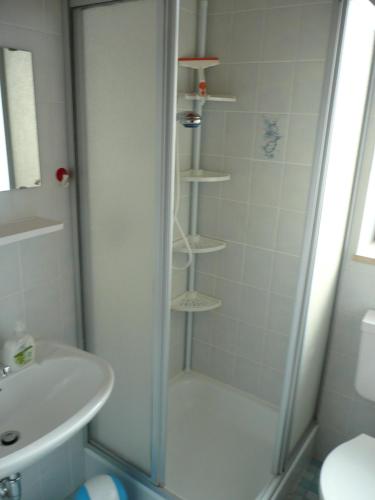 a shower with a glass door next to a sink at Apartment Ahoi in Büsum
