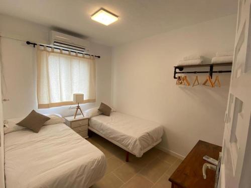 a small room with two beds and a window at Apartamento para 4-5 personas en es Pujols, Formentera in Es Pujols