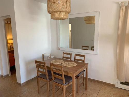 a dining room table with chairs and a mirror at Apartamento para 4-5 personas en es Pujols, Formentera in Es Pujols