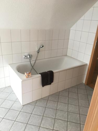 a bath tub with a shower in a bathroom at Deutsches Haus in Willingen