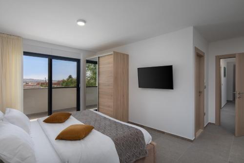 a bedroom with a large bed with a flat screen tv at Luxury Villa IN with Heated Pool in Solin
